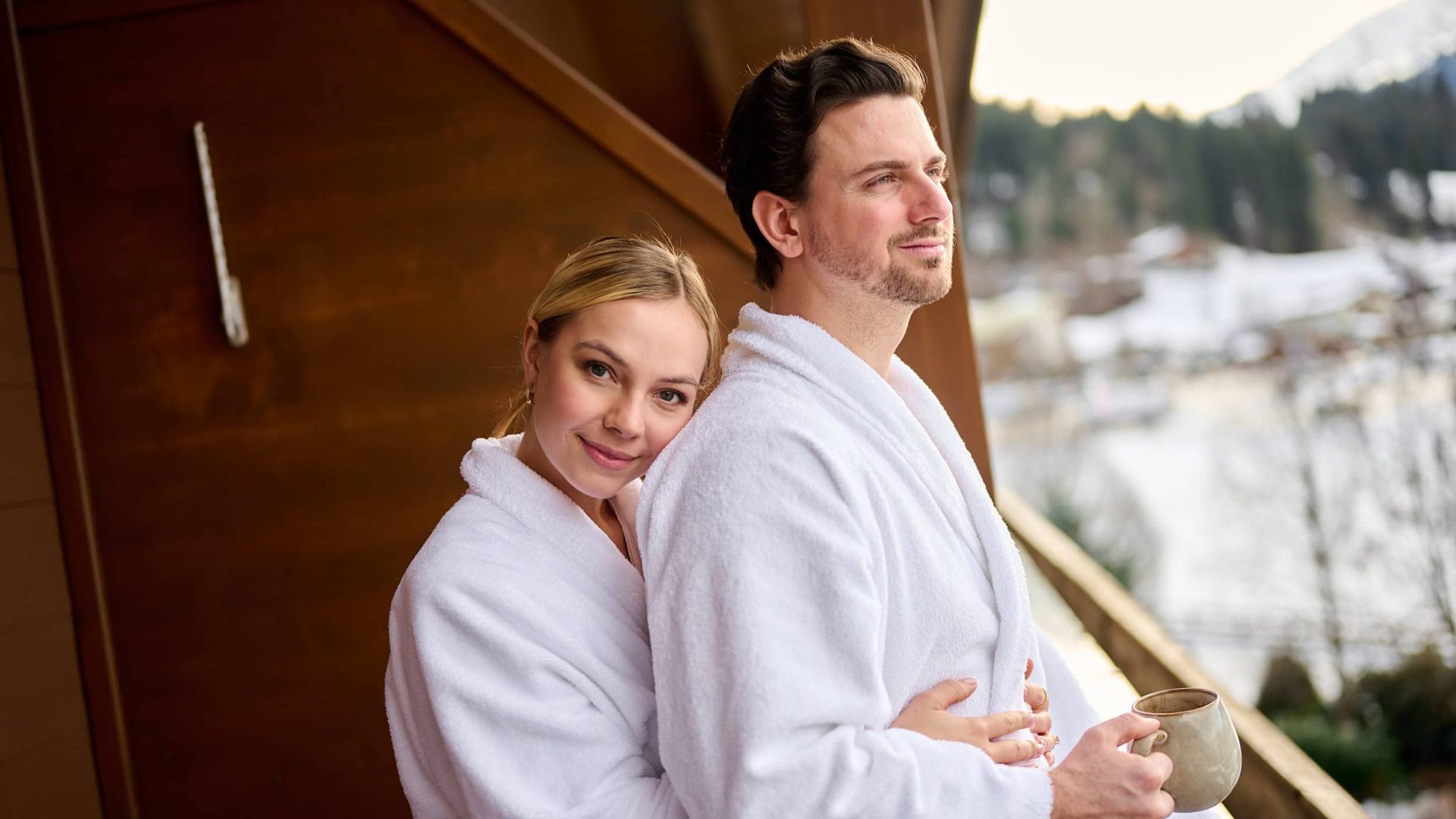 Menschen in Bademänteln genießen Ruhe, Komfort und atemberaubende Panoramen in Tirols Wellnesshotels.