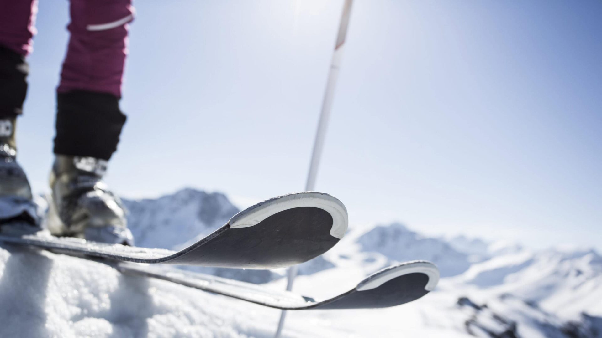 Skifahrer auf verschneitem Berggipfel.