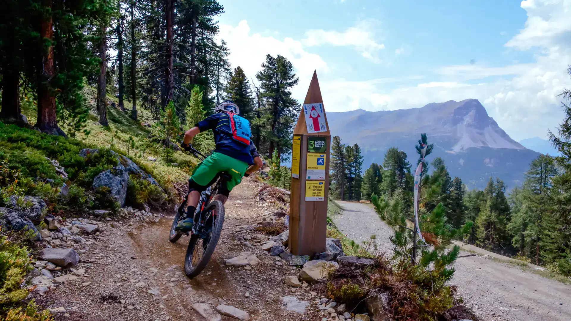 Mountainbiker auf schmalem Trail im Tiroler Wald.