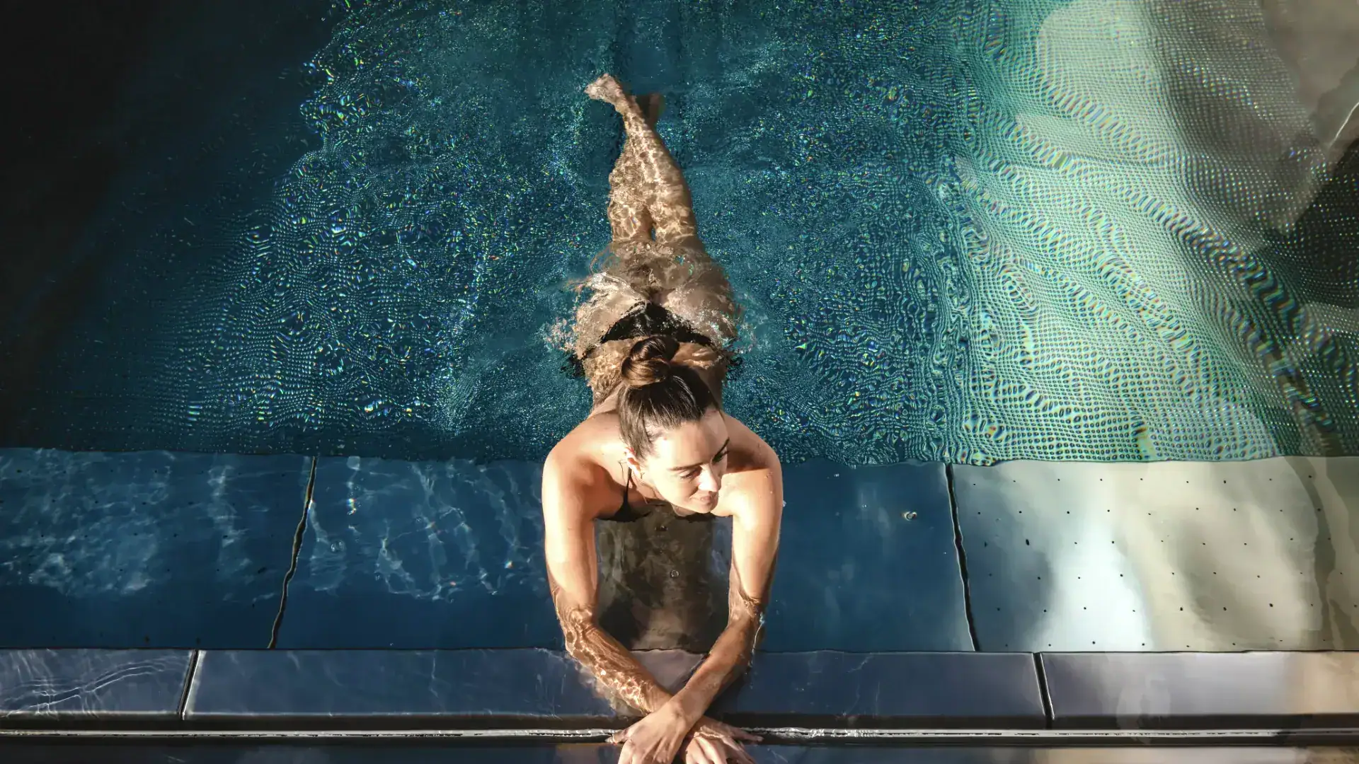Entspannter Mensch beim Schwimmen im Wellnesspool in einem Tiroler Wellnesshotel.