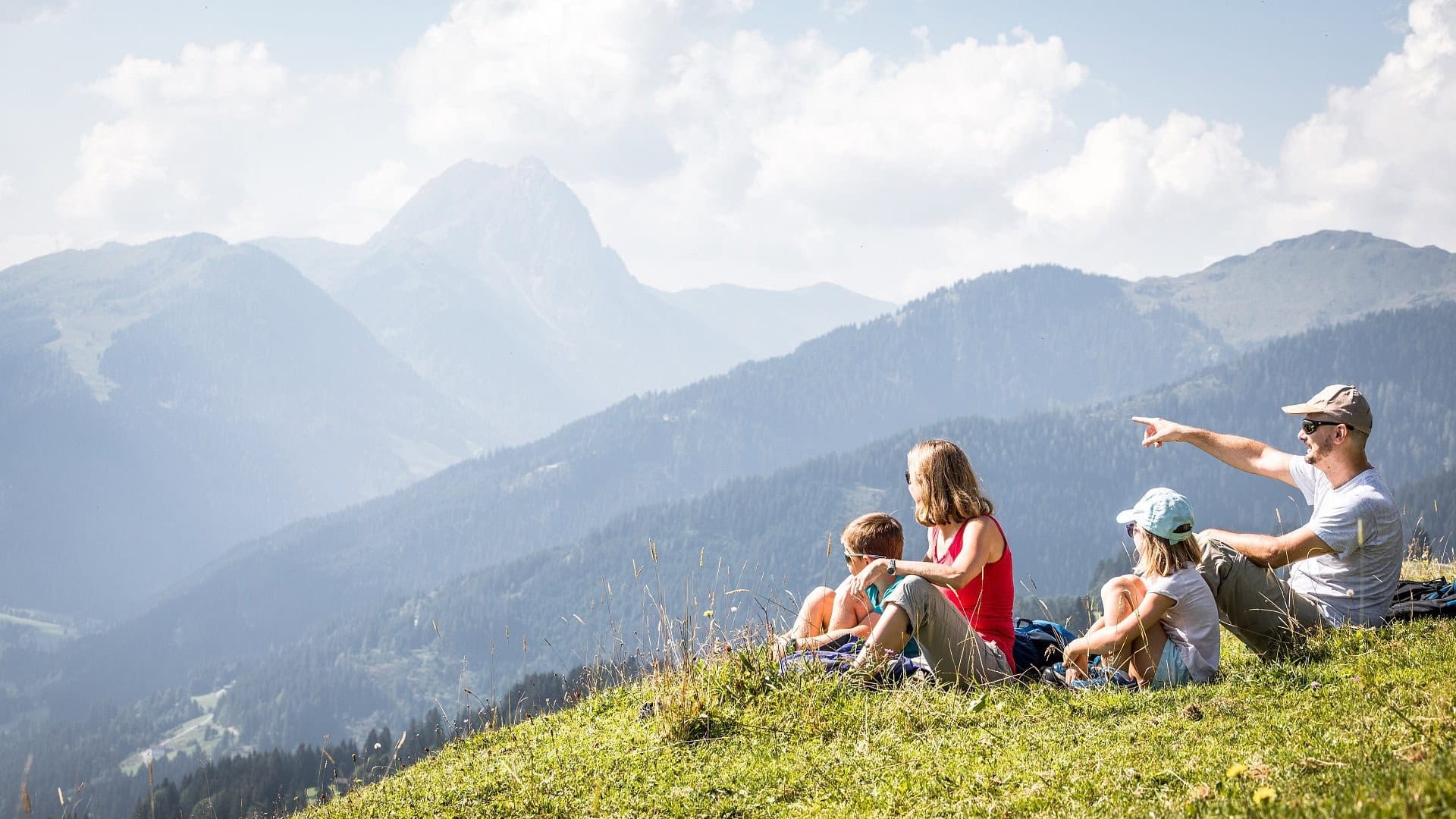Familie mit Kindern genießt den Blick auf die Tiroler Berge im Urlaub.